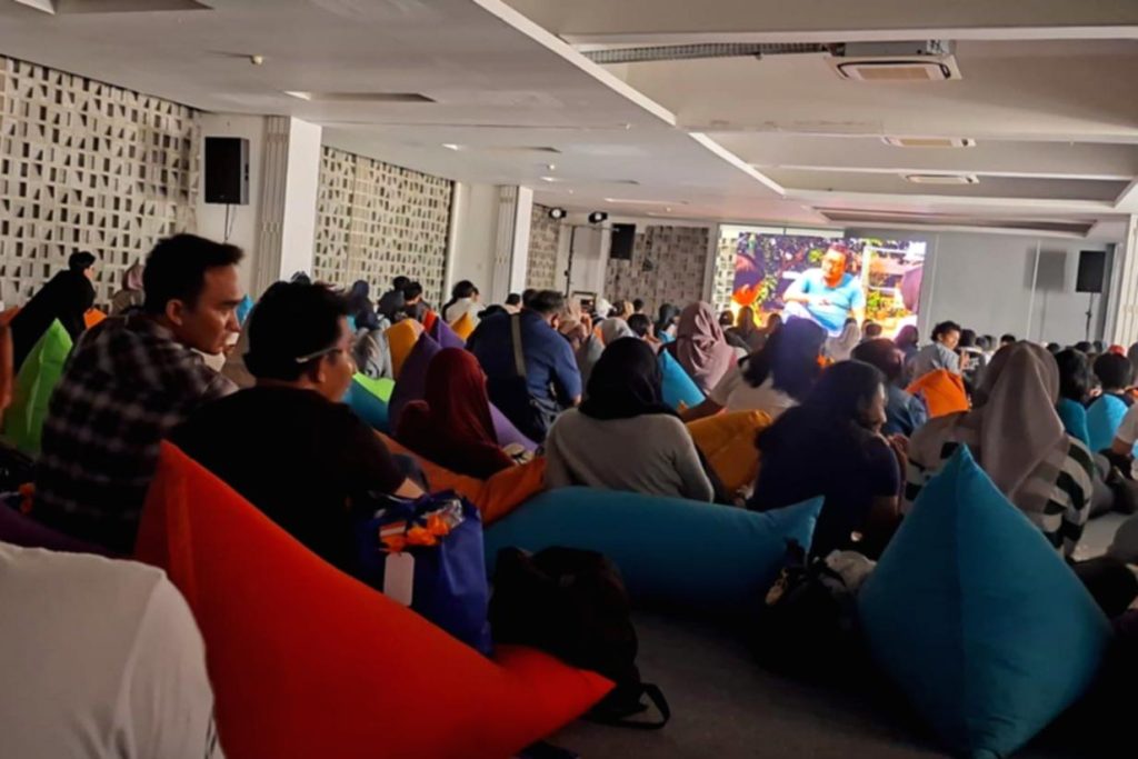 Hundreds of students sit on colorful bean bags watching short films on a large screen at the Jakarta Youth Film Festival 2026.