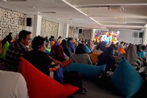 Hundreds of students sit on colorful bean bags watching short films on a large screen at the Jakarta Youth Film Festival 2026.